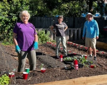A group of people working in a gardenDescription automatically generated